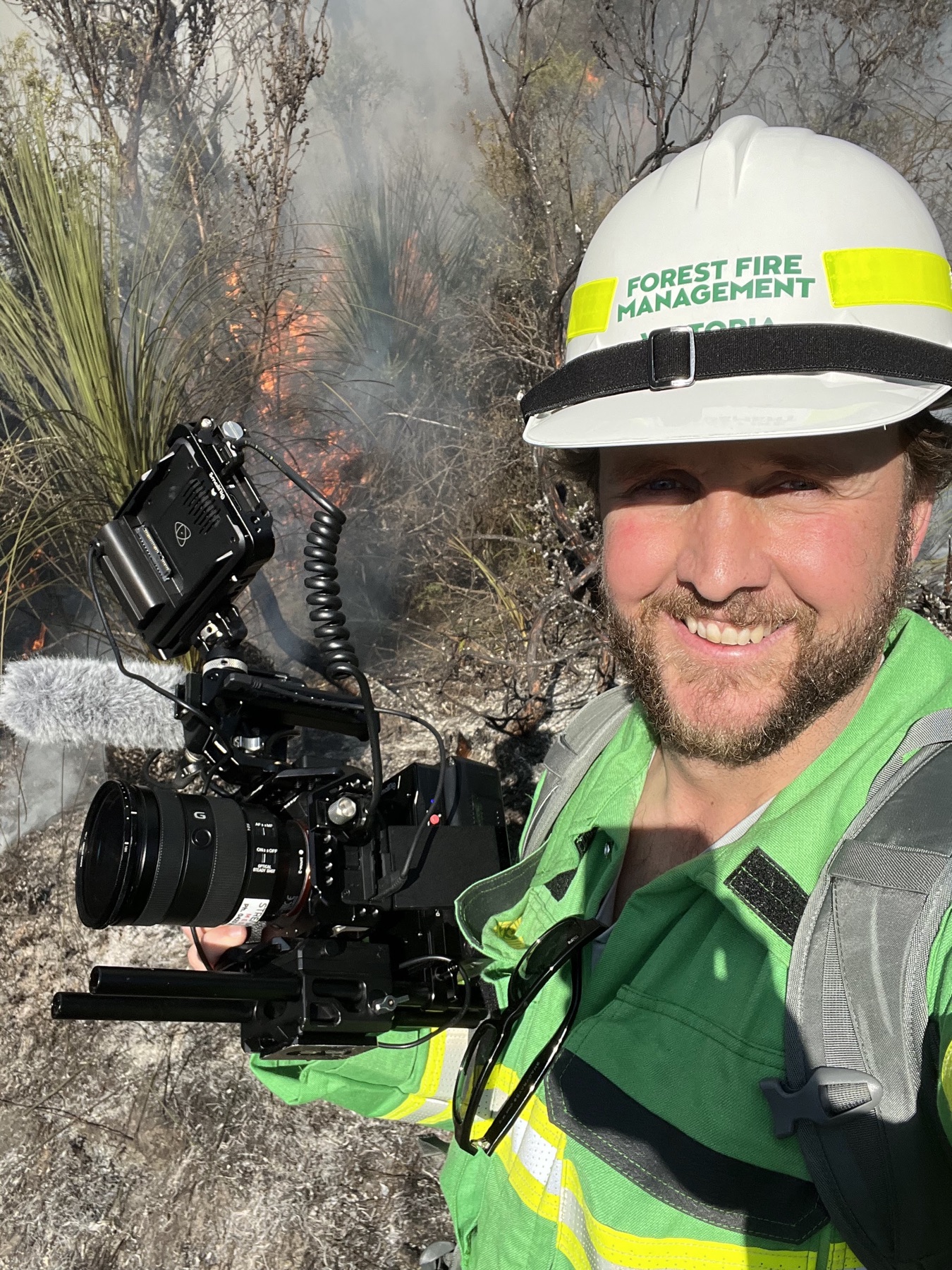 Jarrod Boord filming in the field wearing a forest fire management helmet