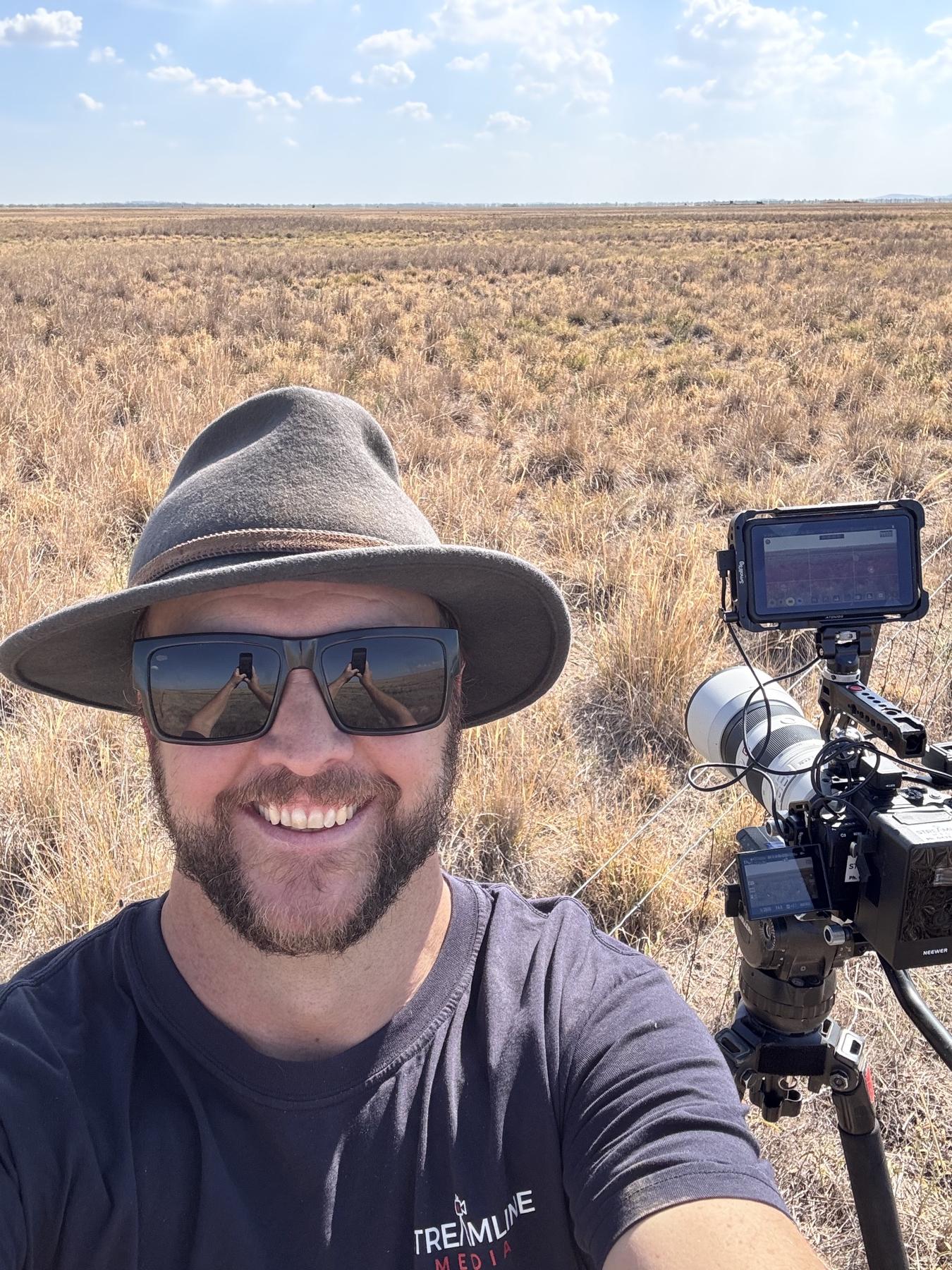 Filming on location in an open landscape